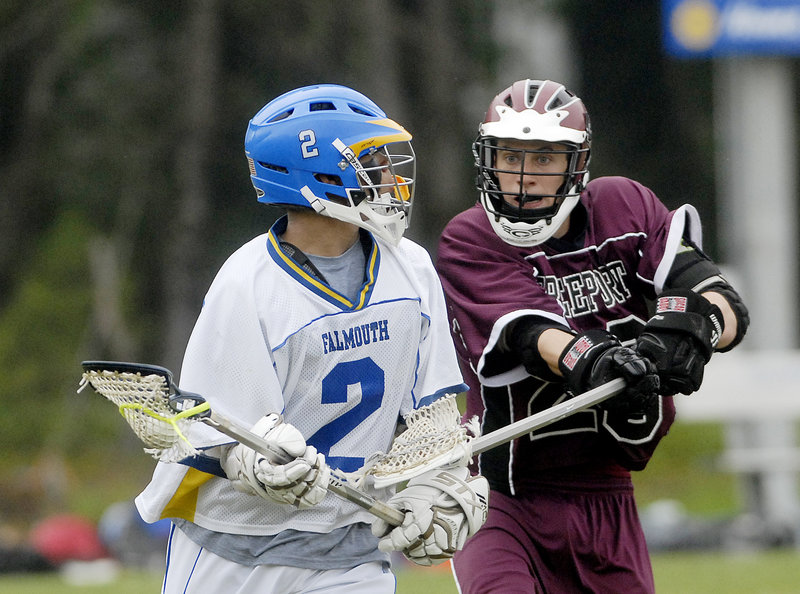 Chris Janelle of Falmouth looks for an open man while trying to protect the ball from Calvin Burgess of Freeport during their regular-season finale at Falmouth.