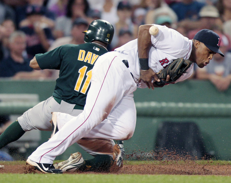 Rajai Davis of the Oakland Athletics slides safely into third base Tuesday night as Adrian Beltre of the Boston Red Sox attempts to control the ball during Boston’s 9-4 victory at Fenway Park. The Red Sox have won 8 of 10.
