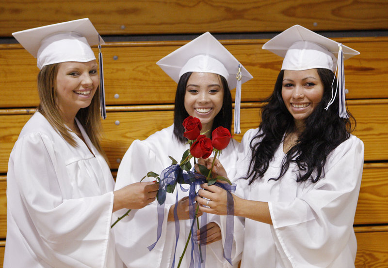 Portland High School seniors Natasha LeClair, from left, Rose Pham and Yuri Shepard-Kegl hold their roses together.