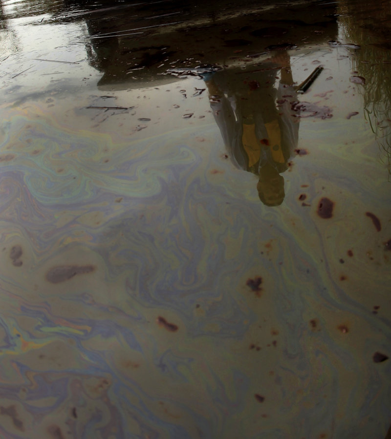 A reporter is reflected in an oily sheen during a tour of an area affected by the Gulf of Mexico oil spill at Pass a Loutre, La., on Wednesday.