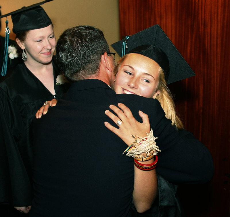 Casco Bay High School teacher Scott Shibles hugs Taylor Boucher during the procession of graduates Wednesday at Merrill Auditorium in Portland.