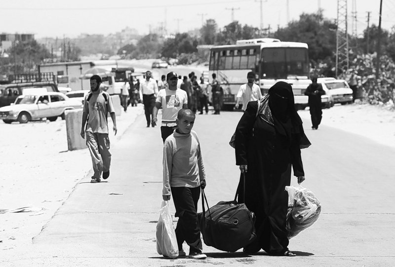 Palestinians carry their luggage to the Rafah border crossing between Egypt and the southern Gaza Strip on Wednesday, after Egypt eased its blockade of Gaza following Israel’s deadly naval raid on an aid flotilla bound for the blockaded Gaza Strip.