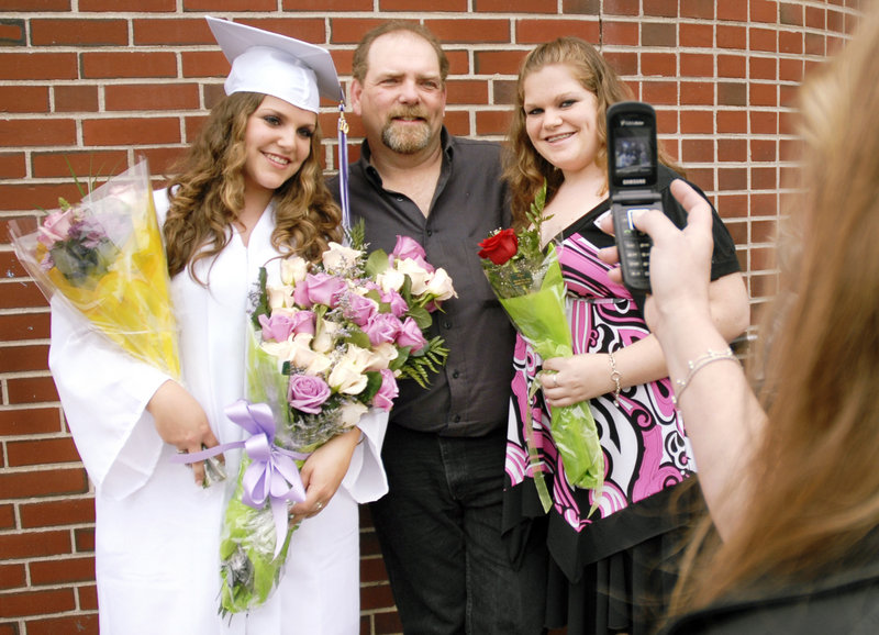Deering High School graduate Elicia Fortier poses with her father, Glenn Fortier, and her sister Michelle in front of the Portland Expo after the graduation ceremony Thursday.