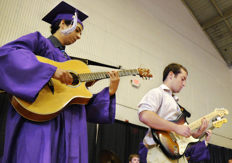 Deering High School senior Jorge Barzallo, left, plays guitar while the senior class sings Journey’s “Don’t Stop Believin’.”