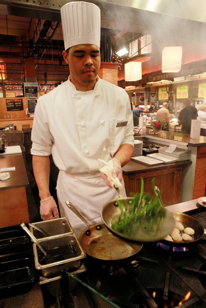 Will Miller prepares Alaskan halibut with pan-seared green beans for customers dining in at the Market Cafe in the Fairfax, Va., Wegmans grocery store.