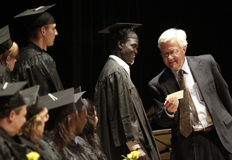 Rob Wood, right, co-director of Portland Adult Education, checks name pronunciation with Tichot Pout Neyail Yei before announcing it during graduation ceremonies.