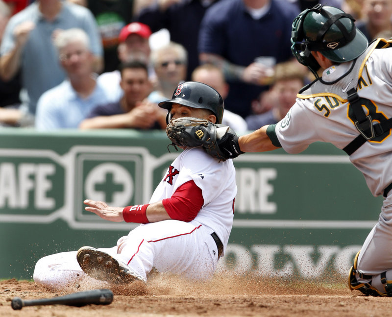 Victor Martinez of the Boston Red Sox is tagged out by Oakland catcher Kurt Suzuki while trying to score on a Kevin Youkilis double in the third inning Thursday. The Red Sox had two runners thrown out at the plate in a 9-8 loss.