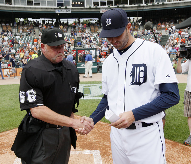 Detroit pitcher Armando Galarraga, who lost his bid for a perfect game on a blown call by umpire Jim Joyce, shakes hands with Joyce while handing over the lineup card Thursday before the Detroit-Cleveland game in Detroit.
