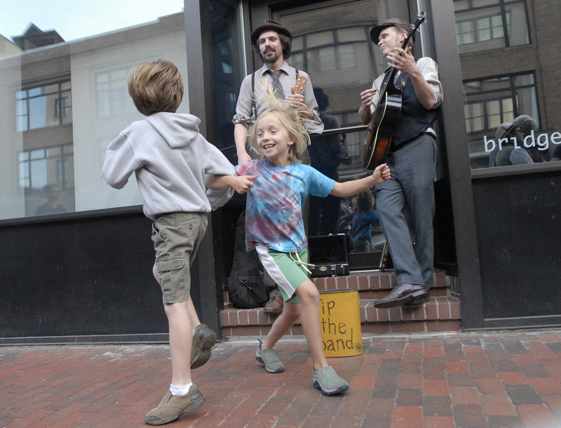 Carly Hagelin, 8, of Portland and Kieran Elliott, 7, of Portland dance as Tim Findler and Jimmy Dority of Portland perform on Congress Street during the First Friday Art Walk.