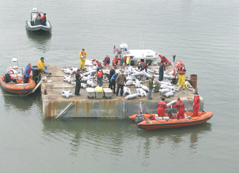 Emergency responders work at the ‘crash scene,’ a barge near the Veterans Memorial Bridge.