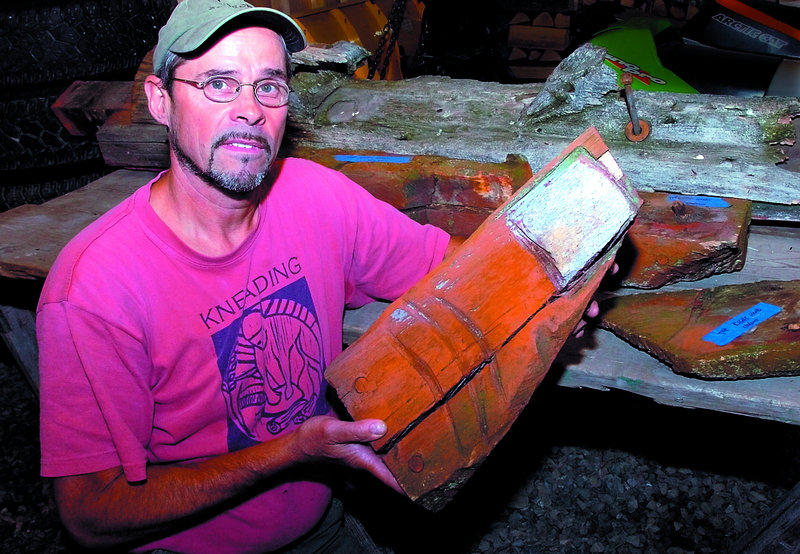Stephen Dionne holds a deteriorated thumb of the Skowhegan Indian sculpture at his shop in Skowhegan. Several other digits and an arm will be restored.