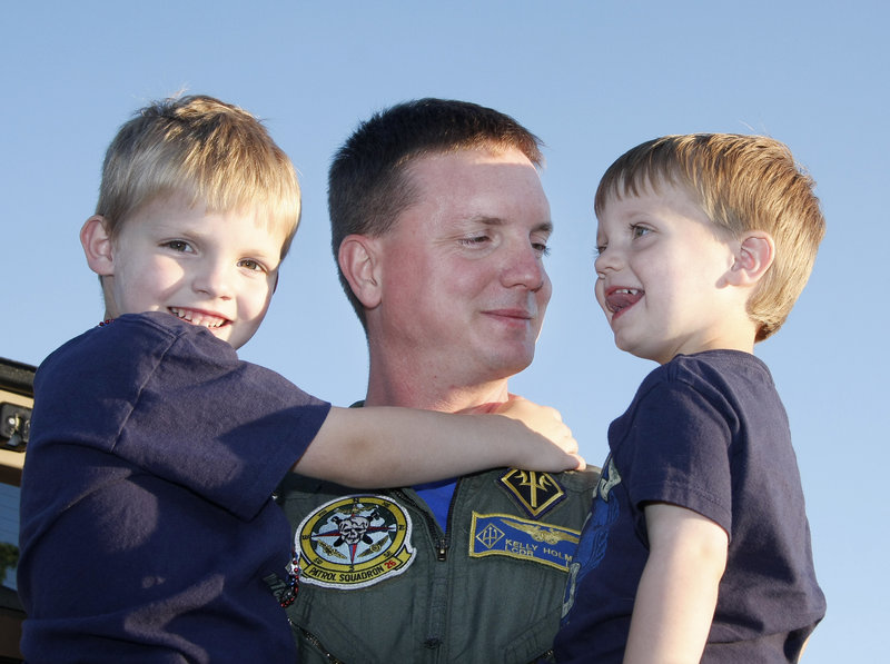 Conor, 6, left, and Cameron, 2, greet their father, Lt. Cmdr. Kelly Holmes, at the Portland jetport on Monday evening. The VP-26, a Navy squadron stationed at Brunswick Naval Air Station, returned after a six-month deployment in Europe, Africa and Central America.