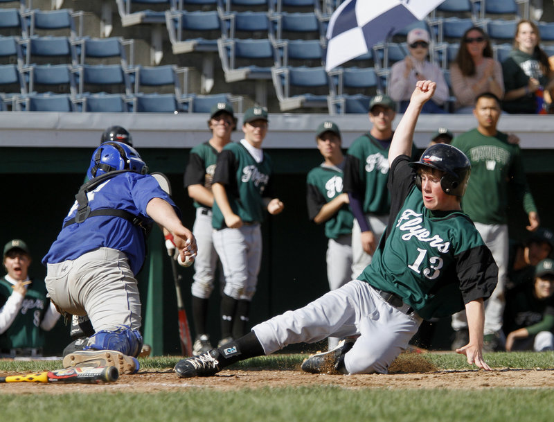 Charlie Laprade of Waynflete slides safely into home as OOB catcher Brandon Ouellette reaches for a wide throw. Ouellette also pitched three innings.
