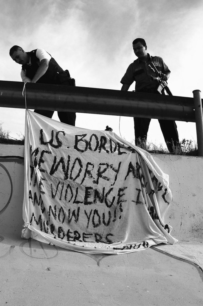 The Associated Press One line for cutline goes to book asjfl;kjasdlk fjasdlaksjfl;kaks Mexican police bring down a banner that was placed near the site where 15 year old Sergio Adrian Hernandez Huereka was shot and killed by a U.S. border patrol agent a day earlier near the Paso del Norte international bridge in the northern border city of Ciudad Juarez, Mexico, Tuesday June 8, 2010. The banner says: U.S. Border Patrol: We are worried about the violence in Mexico and now you!! Murderers! Viva Mexico! (AP Photo)
