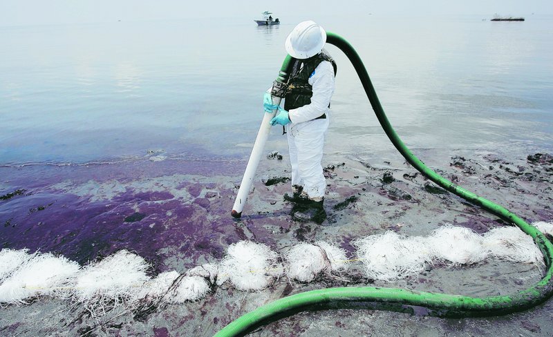 Workers remove oil from the Gulf spill in Pass a Loutre, La. In its response plans, BP said it could marshal enough boats to prevent oil from a deep-water spill from reaching shore.