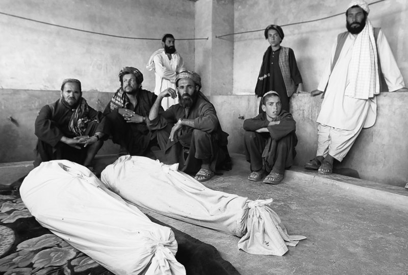 Afghan men gather on Thursday, near the bodies of people killed in Wednesday’s blast in Kandahar’s Argandab district. At least 40 were killed when an explosion ripped through a wedding party, an attack that NATO and the Afghan government say was a suicide bombing by the Taliban. Some local people, however, claim the extensive damage points to an airstrike by coalition forces.