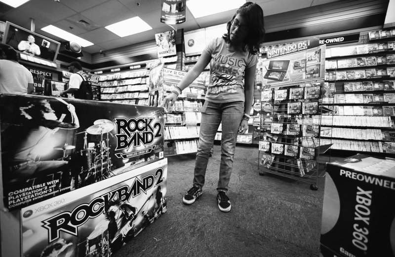 Video gamer Paulette Rivera, 13, checks a guitar for her video console at a Game Stop store in Los Angeles. Manufacturers will be unveiling new products next week at the Electronic Entertainment Expo.
