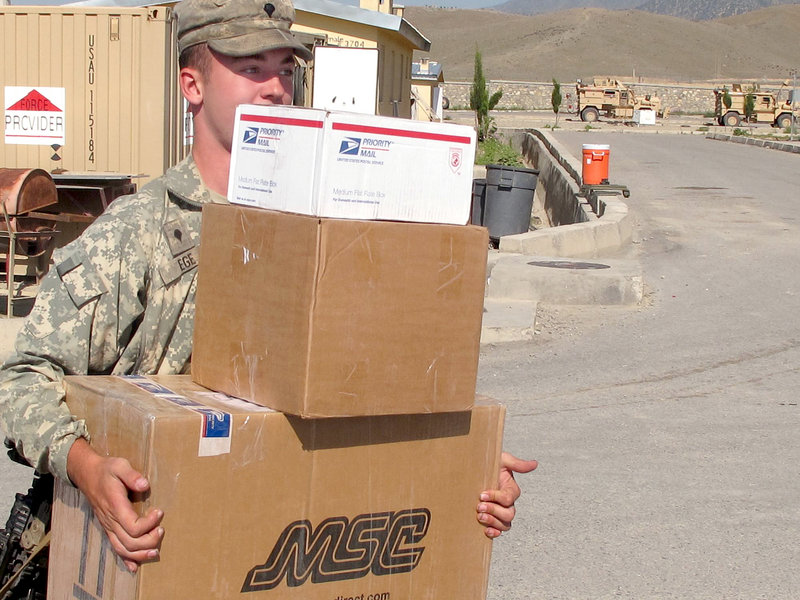 Pfc. Craig Ege of Sanford does some heavy lifting Friday during Bravo Company’s mail delivery at Combat Outpost Dand wa Patan.