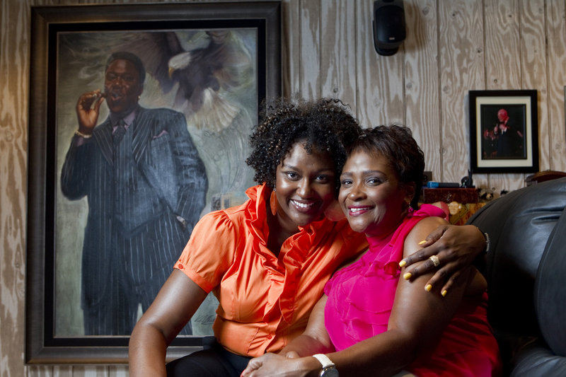 Rhonda McCullough, 51, right, wife of the late comedian Bernie Mac, and their daughter, Je’Niece McCullough, 32, pose near a portrait of Bernie Mac at home in Frankfort, Ill. Rhonda McCullough says that carrying on her late husband’s quest to help those with sarcoidosis, the immune disease he suffered from, is her testament to the man he was.