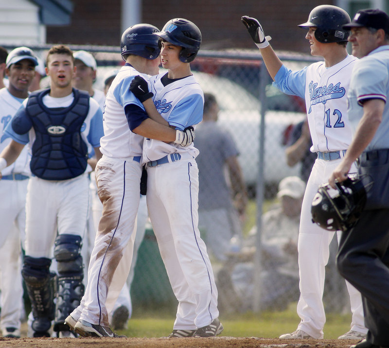 Sam Stauble, left, and Joe Quinlan of Westbrook celebrate Friday after scoring on a two-run double by Scott Heath in the third inning of the 4-0 victory against South Portland. The Blazes will play Deering in the semifinals today.