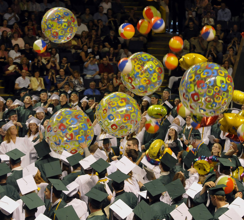 Family and friends applaud at the end of the ceremony as beach balls and balloons fall upon the graduates.