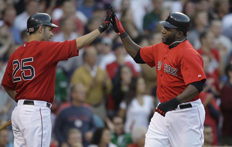 David Ortiz, right, is welcomed by Mike Lowell after scoring on Adrian Beltre’s first-inning double Friday night for the Boston Red Sox in a 12-2 victory against the Philadelphia Phillies at Fenway Park.