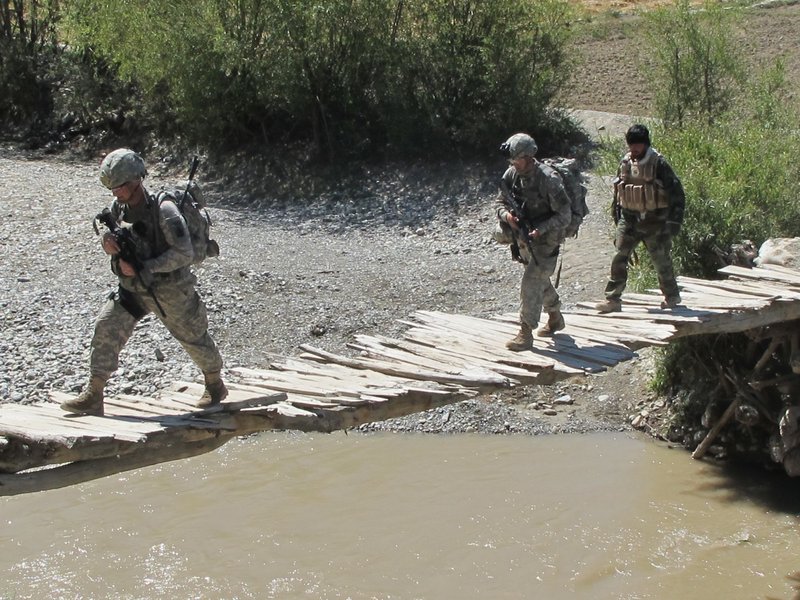 Soldiers from Bravo Company's First Platoon and a member of the Afghan Border Police cross a rickety bridge Saturday near the Afghan village of Meydani.