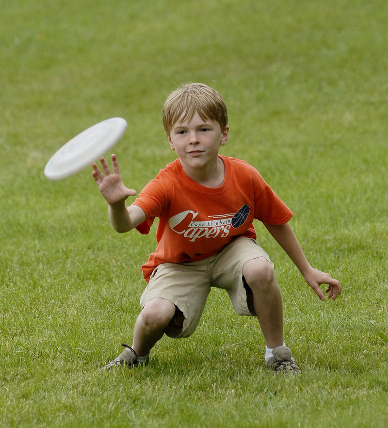 Alex Hansen, 8, reaches for a Frisbee while playing in the park.