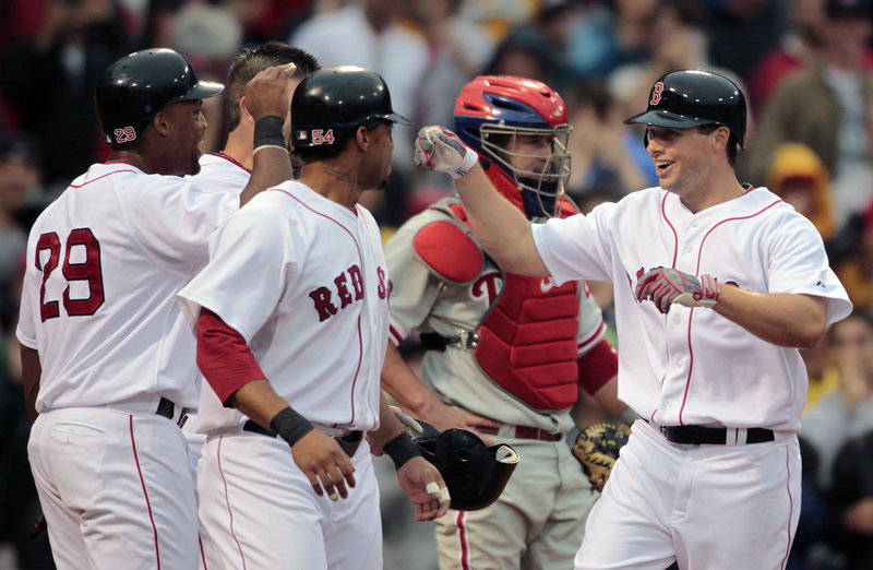 Daniel Nava, right, is greeted by Darnell McDonald, front, Adrian Beltre, left, and Jason Varitek after hitting a grand slam in the second inning Saturday.