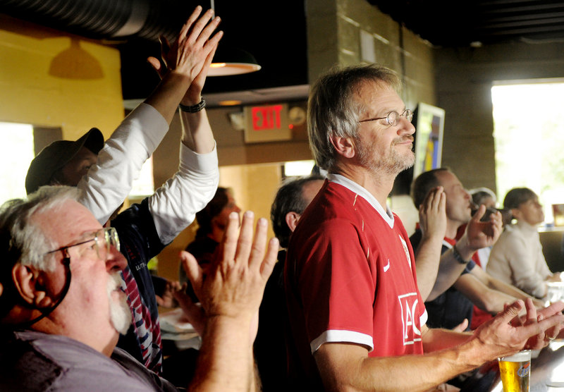Alan Pugsley, in red for Manchester United, reacts as the U.S. team scores a goal in the World Cup game between the U.S. and Pugsley's native England on Saturday. He and other soccer fans watched from G.R. DiMillo's restaurant on Preble Street in Portland.