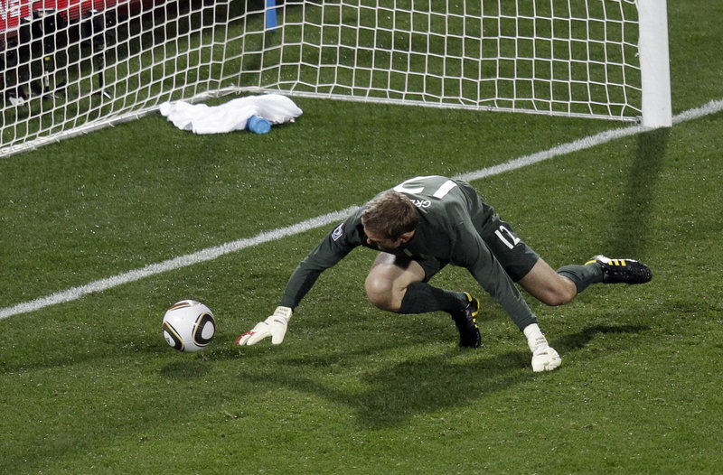 England goalkeeper Robert Green scrambles for the ball after initially stopping American Clint Dempsey’s bouncing 25-yard shot. The ball rolled into the net for a 1-1 tie.