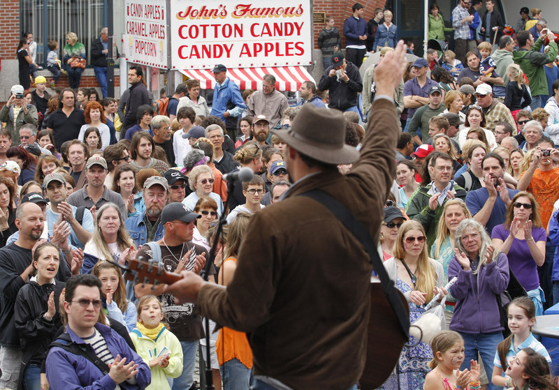 A crowd forms on the corner of Silver and Fore streets to listen to the band Gypsy Tailwind, led by Daniel Connor.