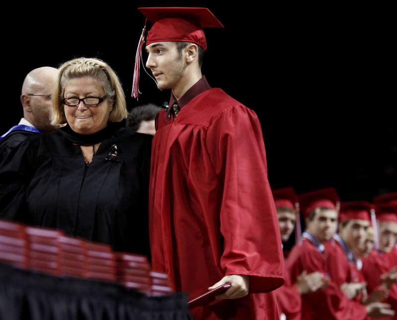 Principal Patricia Conant walks with Kevin Grondin to receive his diploma.