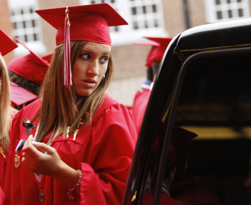 Ellie Morin takes a peek at herself in the reflection of a car window before entering the Cumberland County Civic Center for Scarborough High School's commencement.
