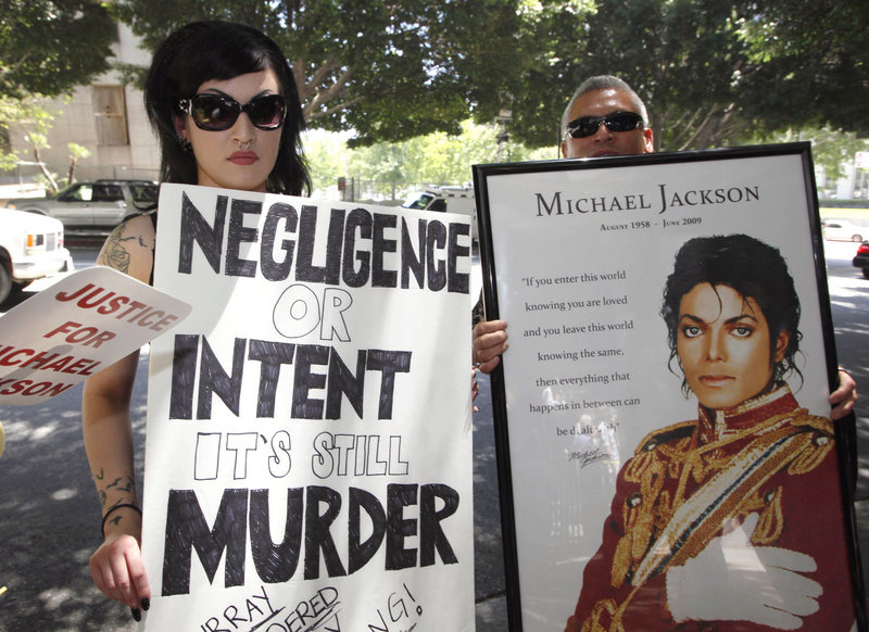 Sheila Baragas holds a poster critical of Dr. Conrad Murray outside a Los Angeles courthouse Monday. A judge said he doesn’t have the authority to revoke the accused doctor’s license.