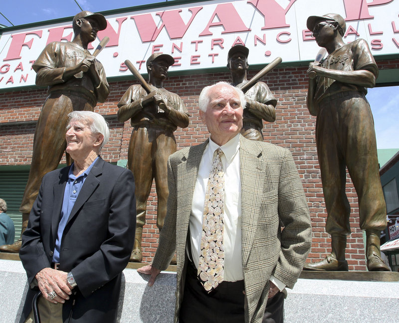 Red Sox legends Johnny Pesky, left, and Bobby Doerr stand before a statue outside Fenway Park depicting them with fellow longtime stars Ted Williams and Dom DiMaggio.
