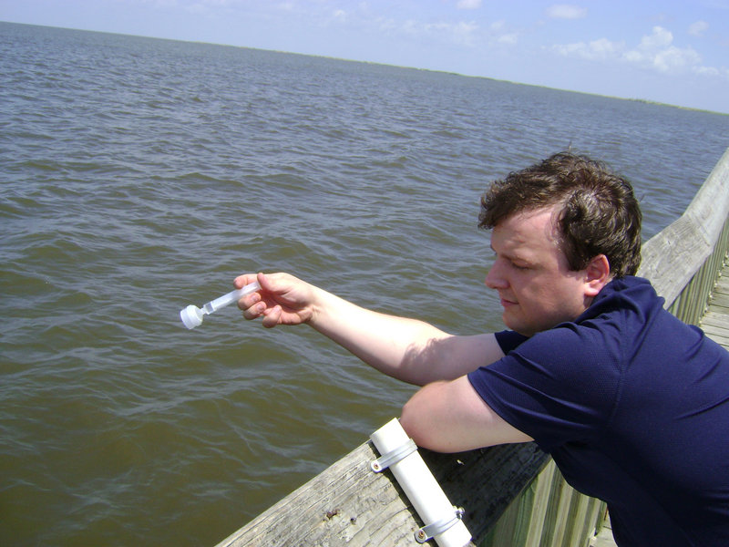 Tom Schwarz of Orono takes a sample of Gulf water from a pier in Cypremort Point State Park in Louisiana. The sample is part of environmental testing.