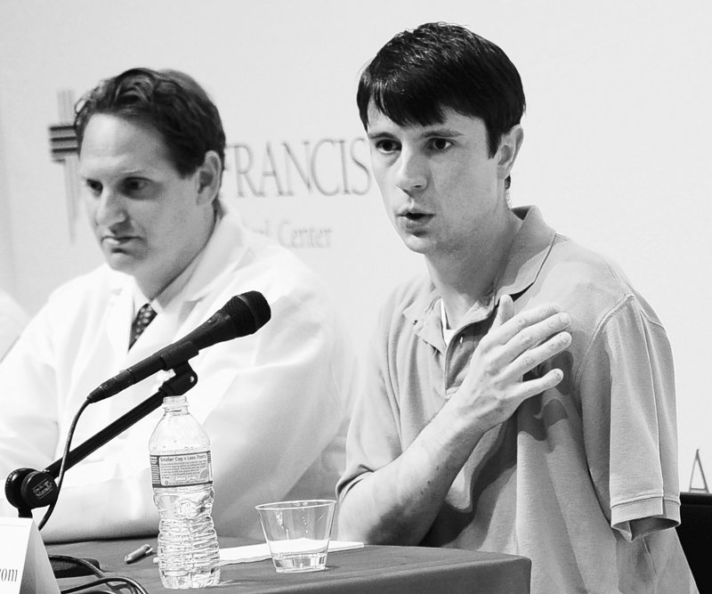 Jonathan Metz, who tried to amputate his left arm to free himself from his furnace boiler, speaks at a news conference Tuesday about his ordeal. At left is Dr. Scott Ellner.