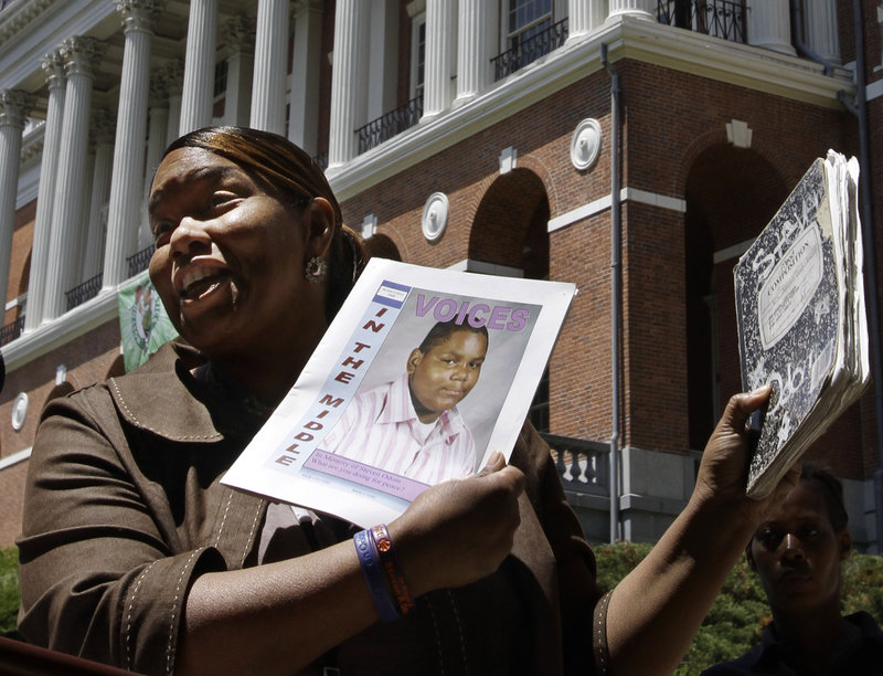 Kim Odom, mother of 13-year-old shooting victim Steven Odom, holds a photo of her son at a rally in front of the Statehouse in Boston on Tuesday. Odom supports a gun bill backed by Gov. Deval Patrick that would limit Massachusetts gun buyers to one firearm per month.