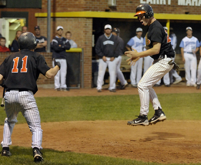 Tyler Audie gives Biddeford the lead in the eighth inning Tuesday night, scoring on a passed ball as teammate Travis Vigneault welcomes him home. The Tigers scored a second run in the inning and went on to defeat Westbrook 4-2 and capture the Western Class A championship.