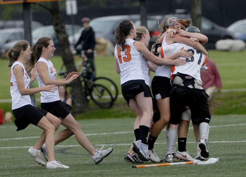 The North Yarmouth Academy girls' lacrosse team begins the celebration Wednesday after avenging two regular-season losses by beating Yarmouth 9-5 in a regional final.