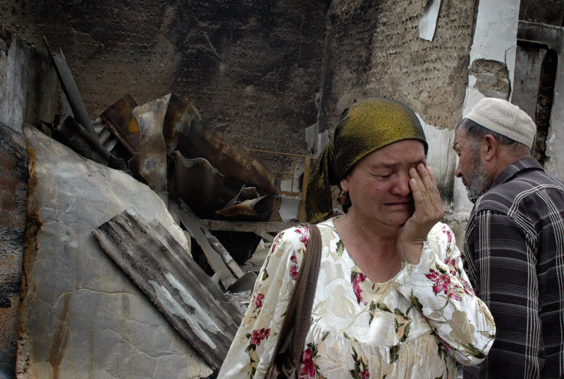 An ethnic Uzbek woman and her husband see that their home has been burned Thursday in Jalal-Abad, Kyrgyzstan, amid the ethnic violence that has killed more than 200 people.