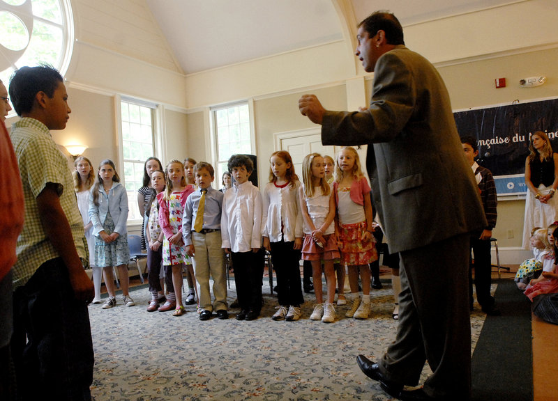 Didier Carribou, a teacher, leads the children in a French song during their end of the year ceremonies held at the South Freeport Church, across the street from the school.