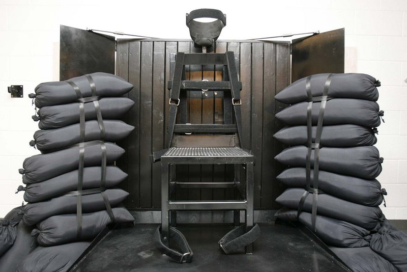 Inmate Ronnie Lee Gardner sat in this chair in the Utah State Prison as he was executed by firing squad early Friday. Bullet holes are visible in the wood panel behind the chair.