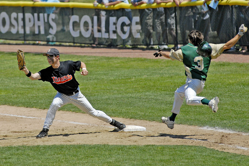 Biddeford first baseman Tyler Audie stretches for the ball for an out Saturday just before Cody Hadley of Oxford Hills reaches the bag. Oxford Hills won the Class A title, 1-0.