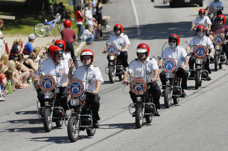 Members of the Kora Cycle Corps rumble in formation on their mini-bikes down the parade route.