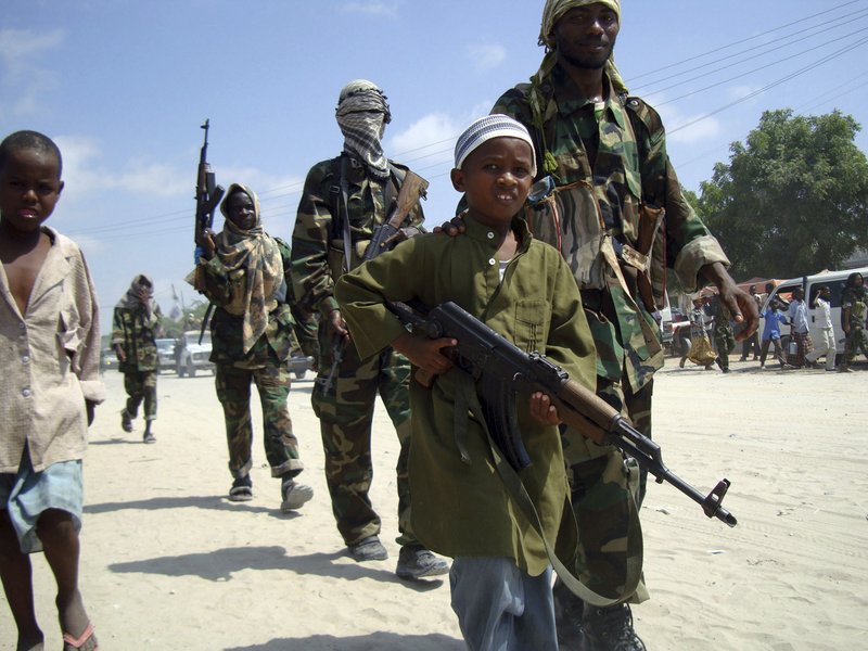 In this January file photo, a young Somali boy leads the hard-line Islamist Al Shabab fighters as they conduct military exercise in northern Mogadishu's Suqaholaha neighborhood.