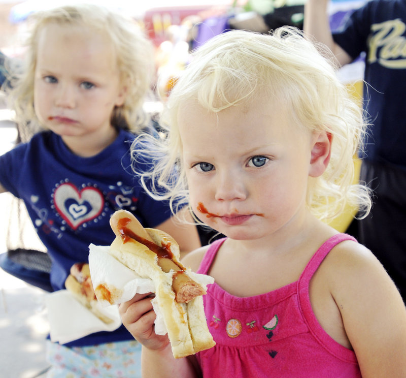 Avery Green, 2, eats a messy hot dog lunch with her sister, Bella, 4, at PeaksFest.