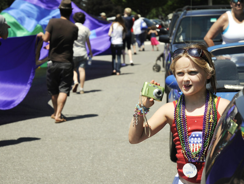 Rhyleigh Metcalf, 7, holds her camera steady as she snaps a photo of the parade.
