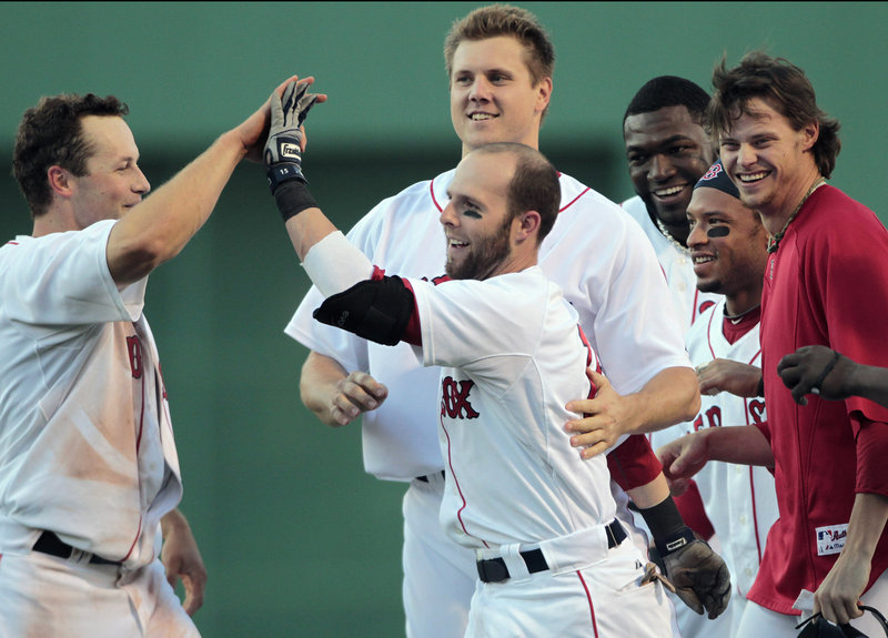 Boston’s Dustin Pedroia, center, celebrates with teammates, from left, Daniel Nava, Jonathan Papelbon, David Ortiz, Darnell McDonald and Clay Buchholz after his walk-off RBI single in the ninth to beat the Dodgers 5-4 Saturday.